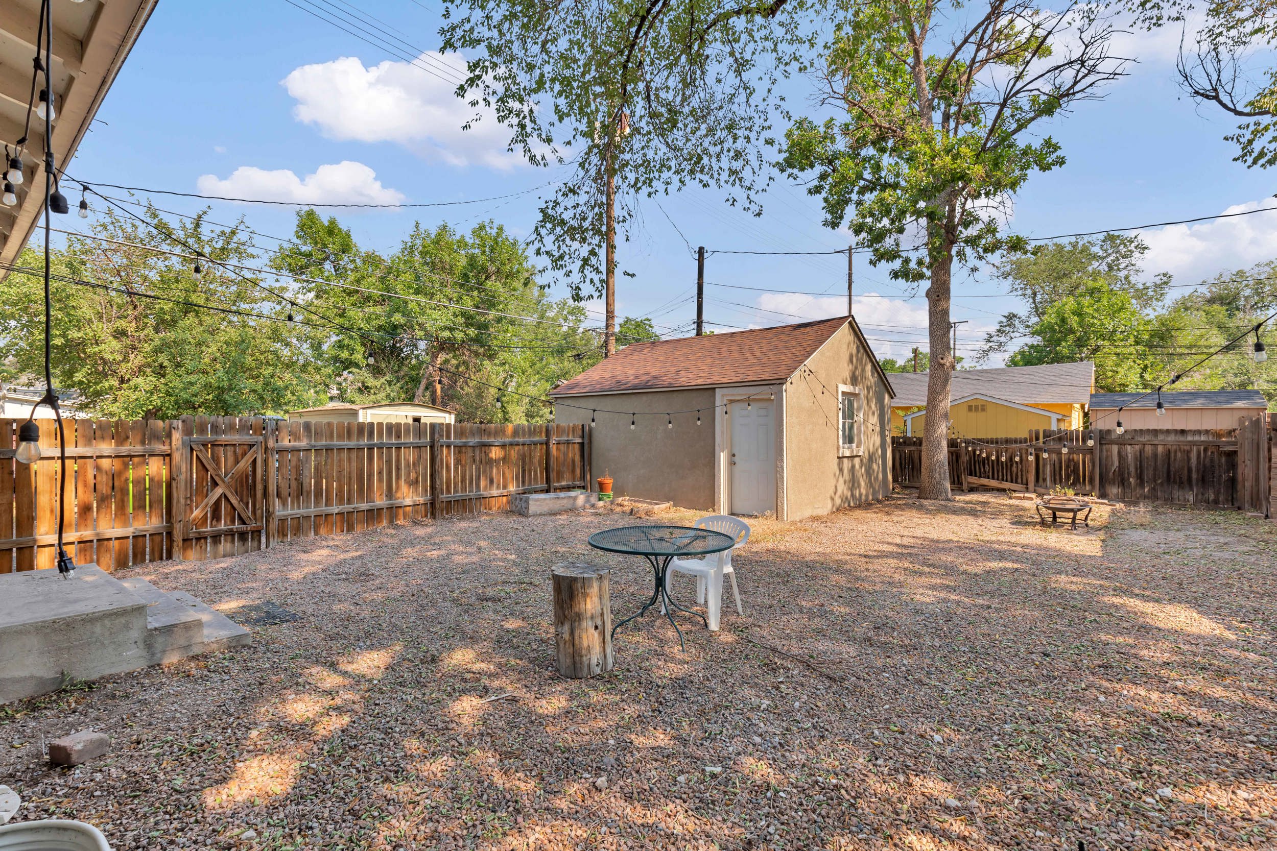 Fully-fenced backyard with storage shed and fire pit